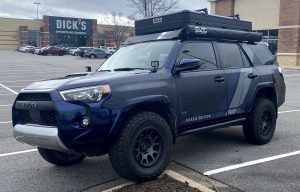 4Runner in a parking lot with one tire on the curb.